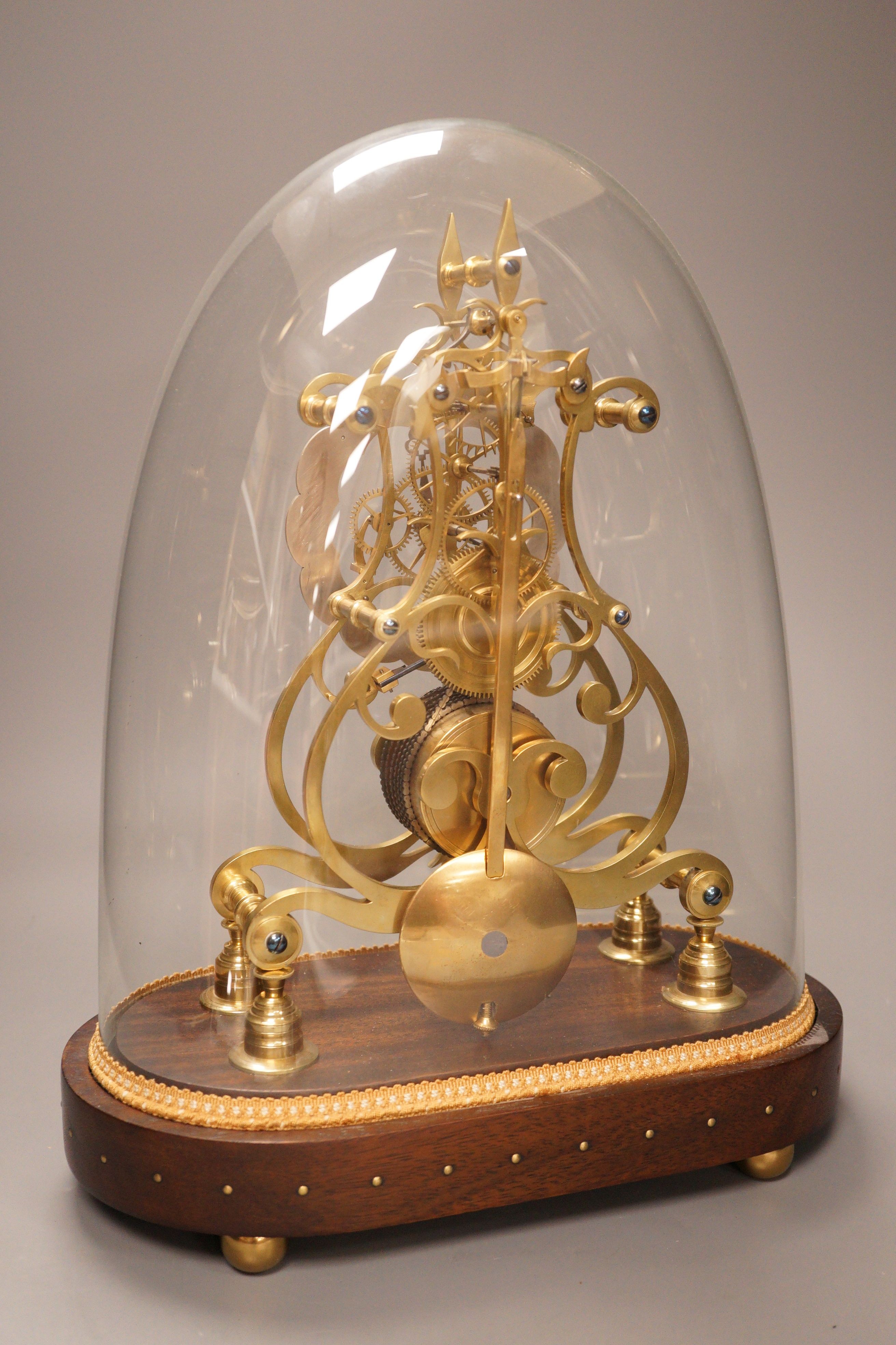 A 19th-century brass single fusee skeleton timepiece under dome, with wall bracket
